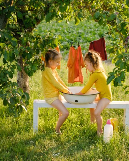 Małe urocze siostry pomagają mamie razem w obowiązkach domowych.
