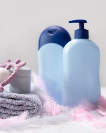 Pieluszki dziecięce i produkty higieniczne do pielęgnacji skóry noworodka na drewnianym stole.