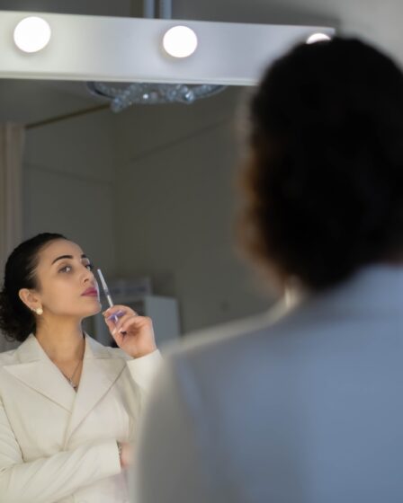 Kosmetolog bada strzykawkę, zastanawiając się nad ryzykiem związanym z zastrzykami kosmetycznymi, podkreślając znaczenie bezpieczeństwa i świadomej zgody w zabiegach estetycznych.